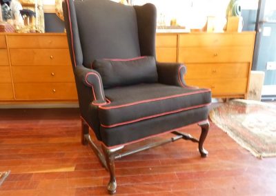 Vintage Wingback Chair in black with red piping